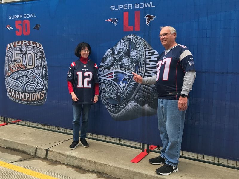 Patriots fans gloat in front of a Super Bowl 51 sign in which their team beat the Atlanta Falcons.