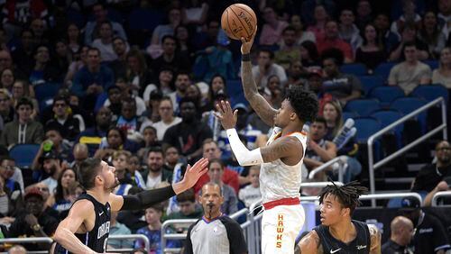 Hawks guard Brandon Goodwin (0)  goes up to shoot between Orlando Magic center Nikola Vucevic (9) and guard Markelle Fultz (20) during the first half Monday, Dec. 30, 2019, in Orlando, Fla.
