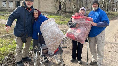 Atlantan Ken Ward (right) stands with three displaced Ukrainians in Kherson, Ukraine. Courtesy of HelpingUkraine.U.S.