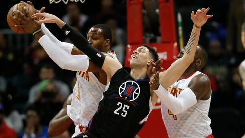 Los Angeles Clippers guard Austin Rivers (25) battles Atlanta Hawks center Dwight Howard (8) and forward Paul Millsap (4) for a rebound in the first half of an NBA basketball game, Monday, Jan. 23, 2017, in Atlanta. (AP Photo/John Bazemore)
