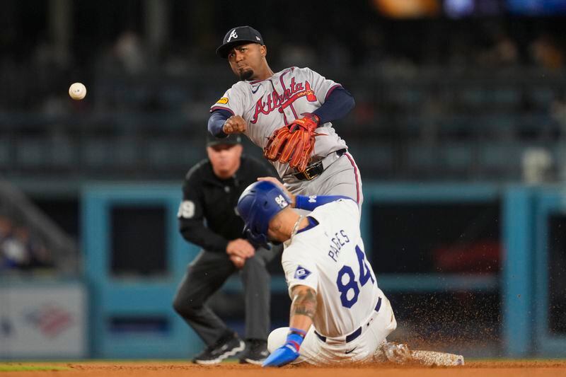 Atlanta Braves second baseman Ozzie Albies (1) throws to first after outting Los Angeles Dodgers' Andy Pages (84) during the seventh inning of a baseball game in Los Angeles, Friday, May 3, 2024. (AP Photo/Ashley Landis)