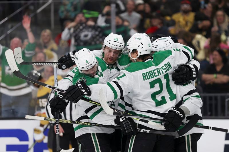 Dallas Stars defensemen Miro Heiskanen (4) and Thomas Harley (55) celebrate after center Wyatt Johnston, right, scored a goal against the Vegas Golden Knights during the first period in Game 3 of an NHL hockey Stanley Cup first-round playoff series Saturday, April 27, 2024, in Las Vegas. (AP Photo/Ian Maule)