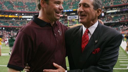 Former Falcons head Coach Jim Mora celebrates with team owner Arthur Blank after a game against the Cardinals at the Georgia Dome on September 26, 2004 in Atlanta.  The Falcons defeated the Cardinals 6-3.