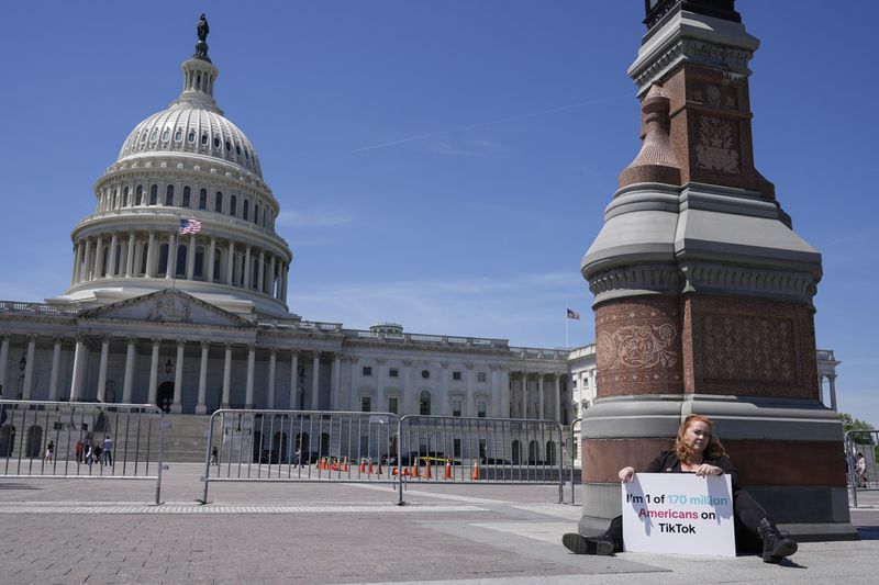 Jennifer Gay, a TikTok content creator, sits outside the U.S. Capitol, Tuesday, April 23, 2024, in Washington as Senators prepare to consider legislation that would force TikTok’s China-based parent company to sell the social media platform under the threat of a ban, a contentious move by U.S. lawmakers. (AP Photo/Mariam Zuhaib)