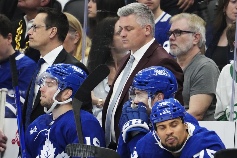 Toronto Maple Leafs head coach Sheldon Keefe, top front right, reacts on the bench with, from bottom left to right, Calle Jarnkrok, Pontus Holmberg and Ryan Reaves during third-period action against the Boston Bruins in Game 4 of an NHL hockey Stanley Cup first-round playoff series in Toronto, Saturday, April 27, 2024. (Frank Gunn/The Canadian Press via AP)
