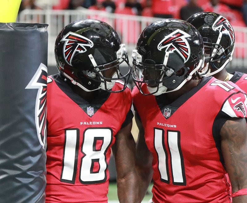Falcons wide receiver Calvin Ridley (18) gets a helmet bump from Julio Jones after his first NFL touchdown against the Panthers on Sunday, Sept 16, 2018, in Atlanta.  (Curtis Compton/ccompton@ajc.com)