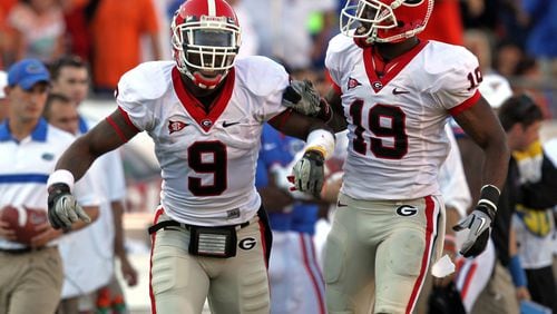 Georgia linebacker Alec Ogletree (9) and cornerback Sanders Commings (19) celebrate a Florida fumble and Georgia recovery in the first half of a 24-20 win over Florida in 2011. Commings has decided to pursue a baseball career and signed a minor-league contract with the Braves this week. (Jason Getz jgetz@ajc.com)