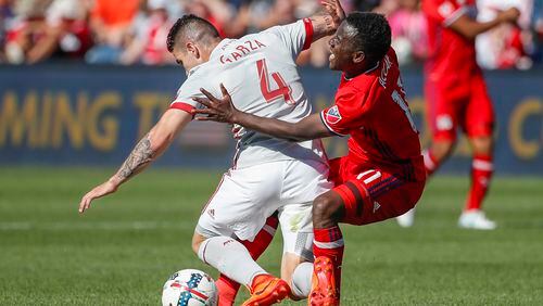 Atlanta United defender Greg Garza, left, tries to keep the ball away from Chicago Fire forward David Accam during the second half of an MLS soccer match, Saturday, June 10, 2017, in Bridgeview, Ill. (AP Photo/Kamil Krzaczynski)
