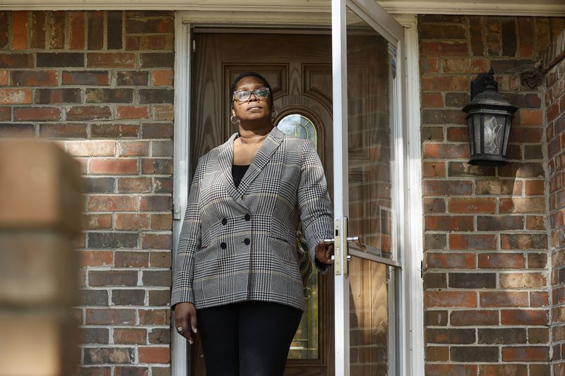 Dele Lowman, seen on her home's front porch in October, has rented two single-family homes in her Stonecrest neighborhood. Both were bought out of foreclosure by investment firms. Her current landlord, Ohio-based VineBrook Homes, bought them in early 2022 when it acquired the entire rental portfolio of nearly 3,000 homes nationwide from another private equity firm for $350 million. (Natrice Miller/natrice.miller@ajc.com)