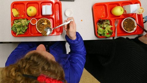 Students eat "veggie chili," cornbread, salad and an apple for lunch at an Atlanta charter school. Nearby City Schools of Decatur is struggling with $88,000 in unpaid meal debt. Starting in February, students who don't have the funds to pay for lunch will get a cheese sandwich and milk. (CURTIS COMPTON / CCOMPTON@AJC.COM)