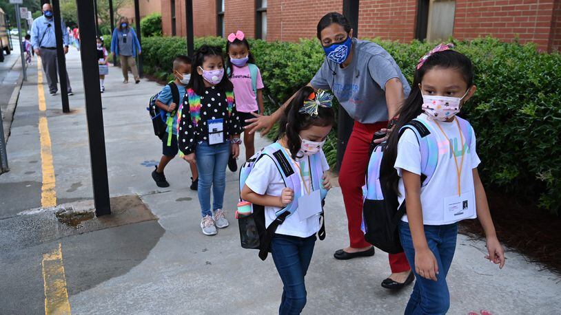 August 26, 2020 Lawrenceville - Deborah Clinkscales, assistant principal, directs students to maintain social distance as students wearing masks arrive to Jackson Elementary School for the first day of school amid the coronavirus outbreak on Wednesday, August 26, 2020. Only kindergartners, first graders and special ed students are coming back, and half the district's students overall have chosen to have in-person instruction this semester. Students are required to wear masks. Hyosub Shin / Hyosub.Shin@ajc.com)