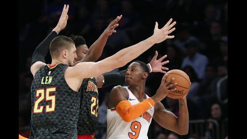 Knicks rookie RJ Barrett (9) looks to pass with Hawks forward Cam Reddish, Barrett's teammate at Duke last season, and center Alex Len defending during the first half of Wednesday's NBA preseason action in New York. (AP Photo/Kathy Willens)