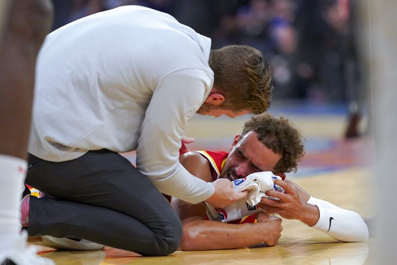 Atlanta Hawks guard Trae Young is checked by a member of the medical staff after he was injured during the second half of the team's NBA basketball game against the New York Knicks, Wednesday, Nov. 2, 2022, at Madison Square Garden in New York. The Hawks won 112-99. (AP Photo/Mary Altaffer)