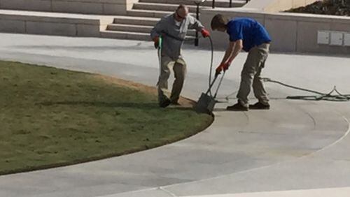 Workers finish up the Liberty Plaza dye job on Monday. (James Salzer/AJC Staff)