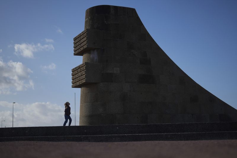 A girl watches the monument called Signal, dedicated to the American soldiers who landed on Omaha Beach on D-Day, on Omaha Beach at sunset, in Saint-Laurent-sur-Mer, Normandy, Tuesday, April 9, 2024. On D-Day, Charles Shay was a 19-year-old Native American army medic who was ready to give his life — and actually saved many. Now 99, he's spreading a message of peace with tireless dedication as he's about to take part in the 80th celebrations of the landings in Normandy that led to the liberation of France and Europe from Nazi Germany occupation. (AP Photo/Thibault Camus)