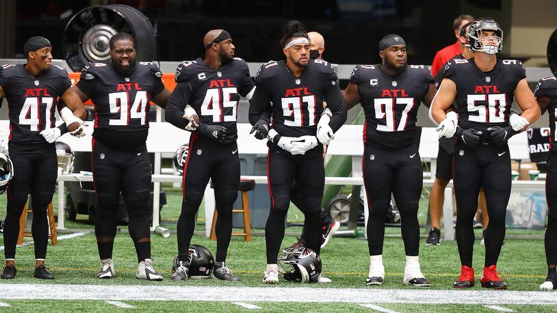 Falcons players join arms for the national anthem to begin the season-opening game against the Seattle Seahawks Sunday, Sept. 13, 2020, at Mercedes-Benz Stadium in Atlanta.  (Curtis Compton / Curtis.Compton@ajc.com)
