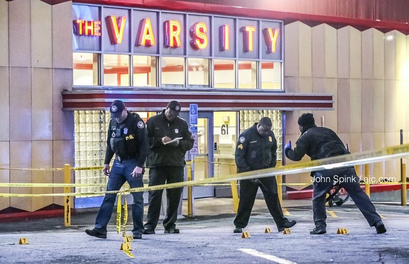 Atlanta police officers collect evidence after a man was shot in the parking lot of the Varsity early Tuesday morning.