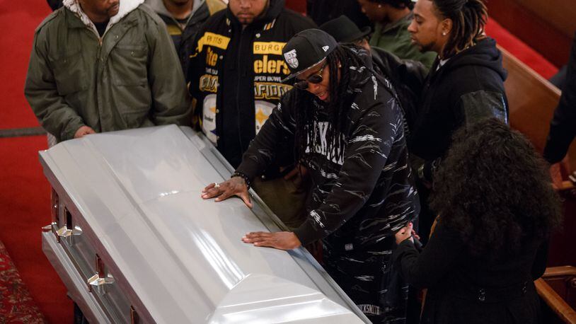 NEW YORK, NY - DECEMBER 05: Friends of Akai Gurley touch his casket at the Brown Memorial Baptist Church on December 5, 2014 in the Brooklyn borough of New York City. Gurley was an unarmed 28-year-old man killed by New York City police officer Peter Liang in a housing development in the East New York neighborhood of Brooklyn on November 20. (Photo by Richard Perry-Pool/Getty Images)