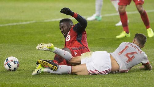 Toronto FC forward Jozy Altidore is brought down by Atlanta United midfielder Carlos Carmona (14) during the first half of an MLS soccer match Saturday, April 8, 2017, in Toronto. (Chris Young/The Canadian Press via AP)