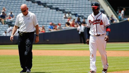 Braves third baseman Adonis Garcia is escorted off the field by trainer Jeff Porter after suffering an injury in the seventh inning against the Cincinnati Reds Thursday, June 16, 2016, at Turner Field in Atlanta.