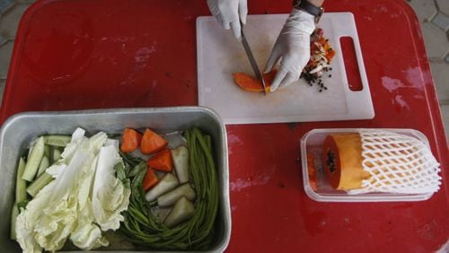 Veterinarian Supakan Kaewchot prepares fresh food for a wild obese macaque called "Uncle Fat" at rehabilitation center Bangkok, Thailand, Friday, May 19, 2017. The morbidly obese wild monkey, who gorged himself on junk food and soda from tourists, has been rescued and placed on a strict diet. (AP Photo/Sakchai Lalit)