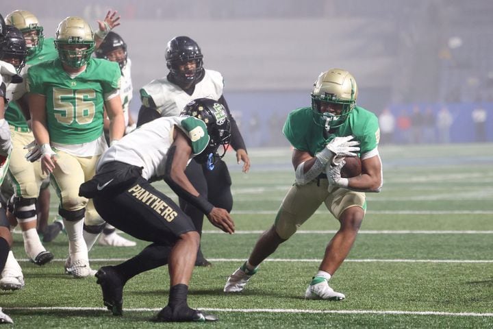 Buford running back CJ Clinkscales (5) scores a touchdown against Langston Hughes defensive back Rodney Shelley (6) during the first half of the Class 6A state title football game at Georgia State Center Parc Stadium Friday, December 10, 2021, Atlanta. JASON GETZ FOR THE ATLANTA JOURNAL-CONSTITUTION