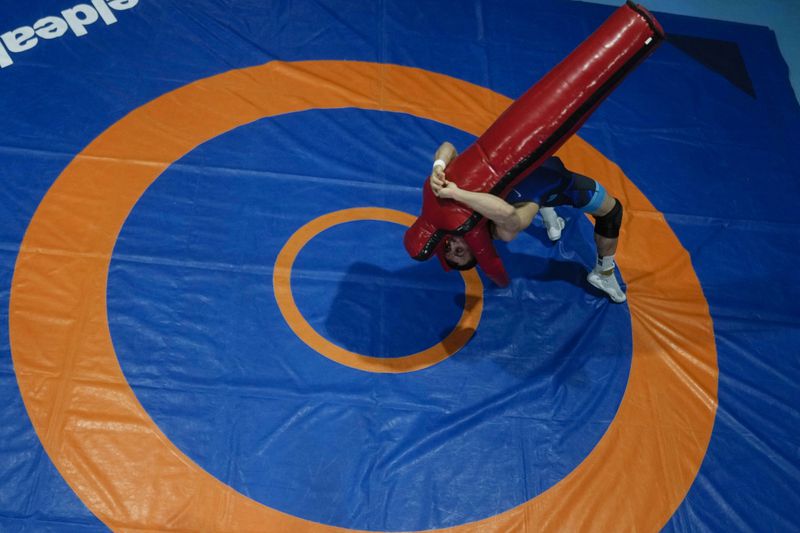 Iranian wrestler Iman Mahdavi, 28, a member of the Refugee Team for the Paris Olympics, practices at the Lotta Club Seggiano gym, in Pioltello, near Milan,Italy, Wednesday, Feb. 28, 2024. The Refugee Team for the Paris Olympics will feature 36 athletes from 11 countries in 12 sports. International Olympic Committee president Thomas Bach says the team was selected from more than 70 scholarships. Instead of competing under the Olympic flag, the refugees will have their own emblem featuring a heart at its center surrounded by arrows. (AP Photo/Luca Bruno)