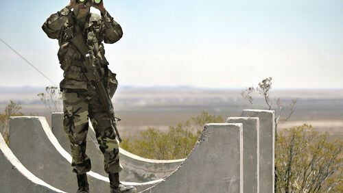 Army National Guard Spc. Gustavo Gutierrez, 23, of Las Cruces, N.M., scans the U.S.-Mexico border from the top of Radar Hill, near Columbus, N.M., on June 12, 2006.