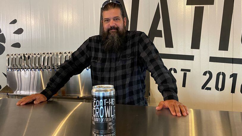 Scofflaw Brewing co-founder and chief brewing officer Travis Herman, shown with a quart growler, is in the taproom at the new Dr. Scofflaw’s Laboratory and Beer Garden, which is dedicated to experimentation. Bob Townsend for The AJC