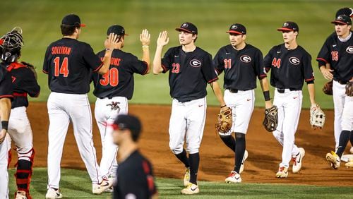 Georgia infielder Connor Tate (23) and Riley King (31) exchange high-fives with teammates after a win over Auburn in Athens on Thursday, April 29, 2021. Their status is uncertain for Tuesday night's road game at Georgia Tech. (Photo by Tony Walsh)