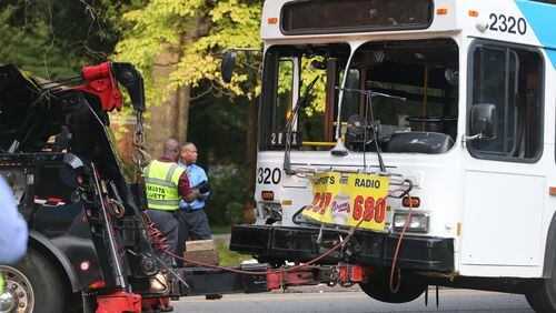 A MARTA bus is hauled away after it was hit by a vehicle that reportedly ran a stop sign at the intersection of Delowe Drive and Woodbury Avenue. (BEN GRAY / BGRAY@AJC.COM)