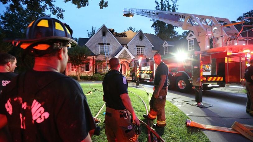 Sandy Springs firefighters respond to a blaze that heavily damaged a home July 10, 2014. Sandy Springs has called a community meeting for 6:30 p.m., March 27, at City Hall to talk about a possible new fire station serving the Panhandle area of the city. JOHN SPINK / AJC