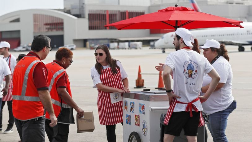 August 8, 2019, 2019 - Atlanta - Catherine Sirna (center), a Delta employee, takes ice cream orders out on the tarmac. After a hot summer of heaving heavy bags at the world’s busiest airport, Delta thanked its baggage handlers with cold drinks, ice cream and juice bars at an end-of-summer event on the tarmac Thursday. Bob Andres / robert.andres@ajc.com