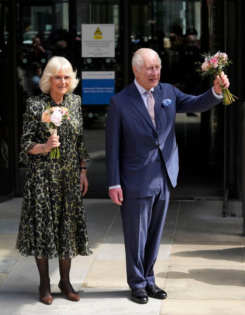 Britain's King Charles III and Queen Camilla hold flowers they were given as they leave after a visit to University College Hospital Macmillan Cancer Centre in London, Tuesday, April 30, 2024. The King, Patron of Cancer Research UK and Macmillan Cancer Support, and Queen Camilla visited the University College Hospital Macmillan Cancer Centre, meeting patients and staff. This visit is to raise awareness of the importance of early diagnosis and will highlight some of the innovative research, supported by Cancer Research UK, which is taking place at the hospital. (AP Photo/Kin Cheung)