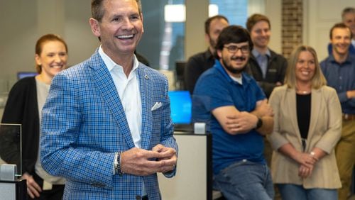 Pat Flood shares a laugh during a group meeting at Supreme Lending in Alpharetta for the Top Workplace medium sized business. PHIL SKINNER FOR THE ATLANTA JOURNAL-CONSTITUTION
