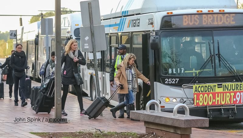 MARTA riders headed to the airport board shuttle buses at the College Park station Thursday. (Photo: JOHN SPINK / JSPINK@AJC.COM)