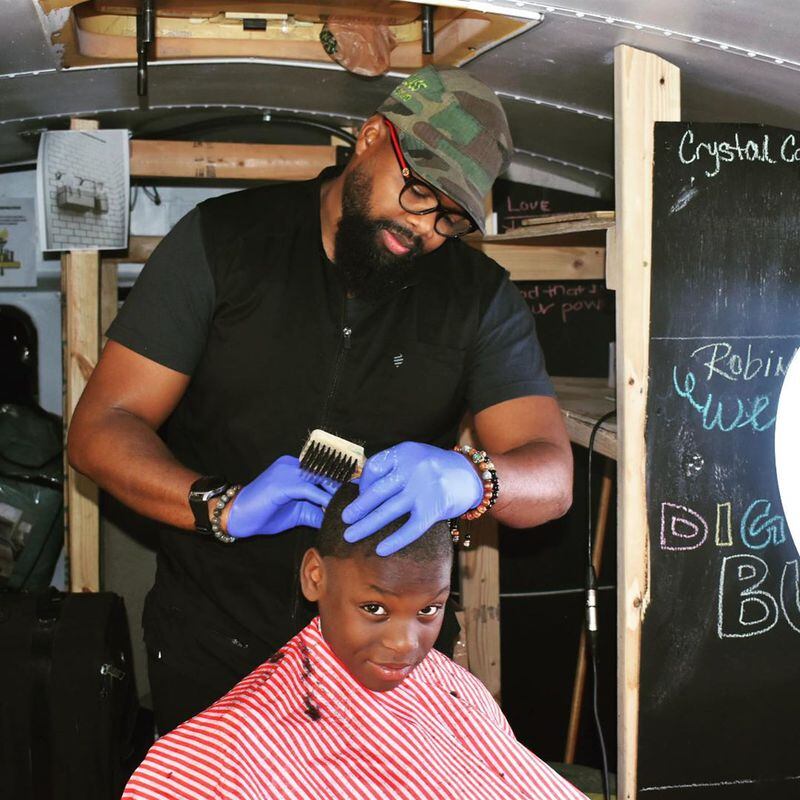 A child gets his haircut on the Dignity Bus during Thanksgiving weekend 2019.
