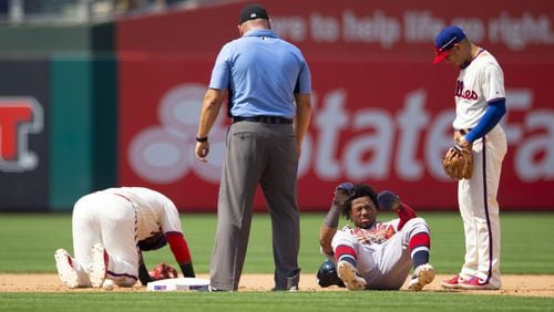 Umpire Mark Carlson and Phillies' Cesar Hernandez (right) check on Jean Segura (left) and Ronald Acuna after they collided in the top of the seventh inning July 28, 2019, at Citizens Bank Park in Philadelphia.