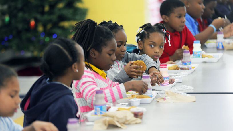 Students eat lunch at Stewart County Elementary School. All of the county’s 515 students receive free breakfasts and lunches. And if the county wins a federal grant, its students will start receiving free dinners. BOB ANDRES /BANDRES@AJC.COM