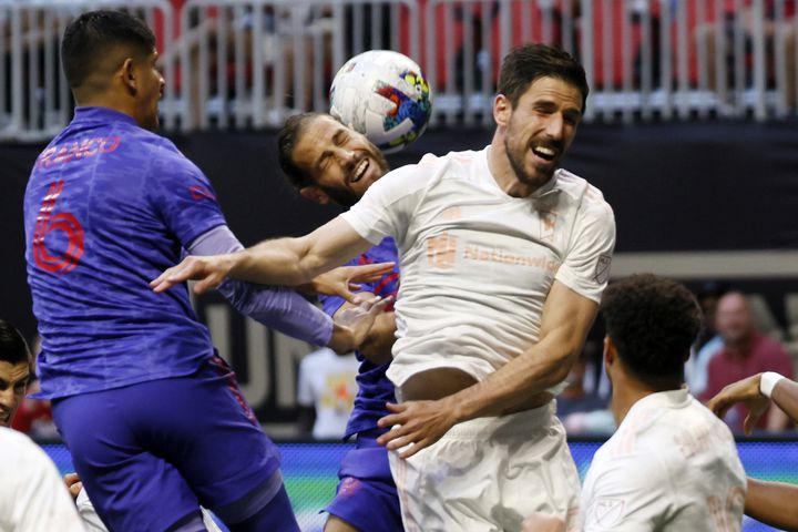 Atlanta United defender Alex de John (center) tries to connect with a header between Columbus Crew defenders in the first half of an MLS soccer match at Mercedes-Benz Stadium on Saturday, May 28, 2022. Miguel Martinez / miguel.martinezjimenez@ajc.com