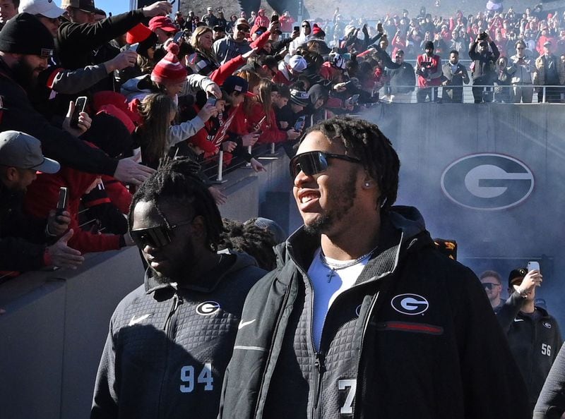Georgia offensive lineman Devin Willock (77) enters the stadium Saturday during the Bulldogs' celebration in Athens. Willock and football staff member Chandler LeCroy died in a car accident early Sunday. Two other members of the football program also were injured and are in stable condition. (Hyosub Shin / Hyosub.Shin@ajc.com)
