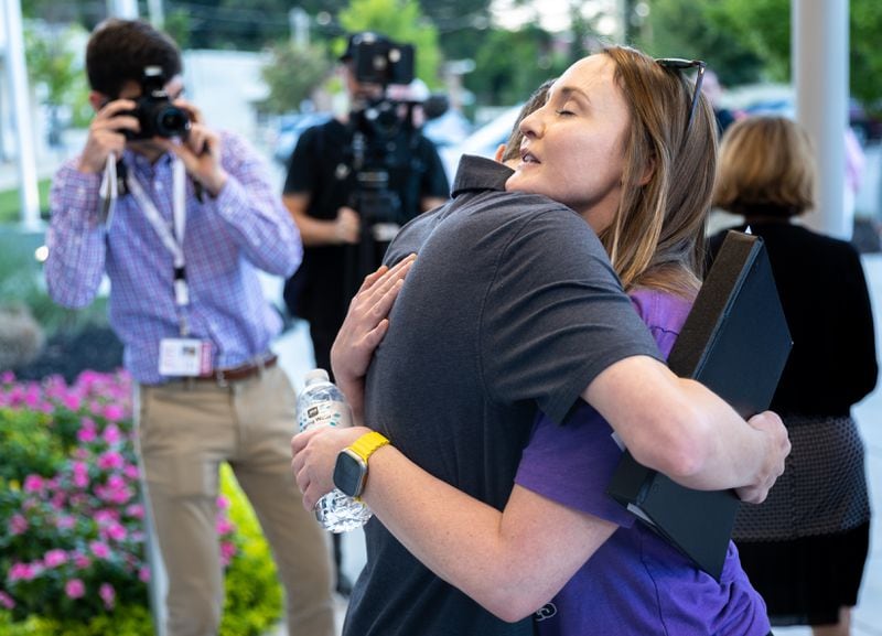 Cobb teacher Katie Rinderle (right) embraces Jack Lakis, a recent Harrison High School graduate, after a Cobb County school board meeting in Marietta on Thursday, August 17, 2023. The school board voted to fire Rinderle, who read a book that challenges gender norms to fifth grade students. (Arvin Temkar/arvin.temkar@ajc.com)