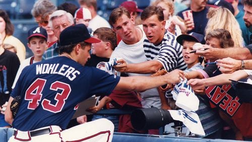 Braves pitcher Mark Wohlers, who was a member of the Altanta trio that combined to no-hit the San Diego Padres two days prior signs autographs for fans before a game. Sept. 13, 1991, in Atlanta.