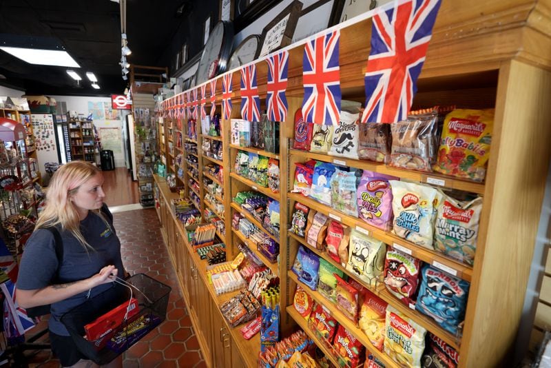 Wendy Tribble, of Suwanee, buys snacks and candies for her father at the Taste of Britain shop in downtown Norcross, Tuesday, September 13, 2022, in Norcross. Taste of Britain is the go-to place for anything British. With the death of Queen Elizabeth, it’s also a place where shoppers can buy an array of queen-themed merchandise. (Jason Getz / Jason.Getz@ajc.com)
