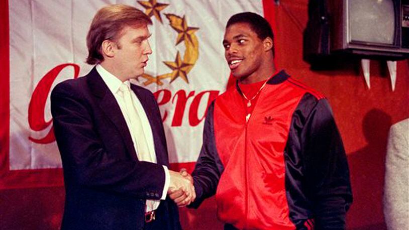 FILE - In this March 8, 1984, file photo, Donald Trump shakes hands with Herschel Walker in New York after agreement on a 4-year contract with the New Jersey Generals USFL football team. The New Jersey Generals have been largely forgotten, but Trump�s ownership of the team was formative in his evolution as a public figure and peerless self-publicist. With money and swagger, he led a shaky and relatively low-budget spring football league, the USFL, into a showdown with the NFL. (AP Photo/Dave Pickoff, File)