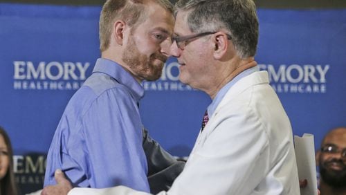 Aug. 21: Dr. Kent Brantly (left) embraces Director of Emory’s Infectious Diseases Unit, Dr. Bruce Ribner, after he made a statement at Emory University Hospital annex following his discharge. JOHN SPINK/JSPINK@AJC.COM