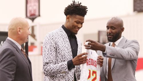 Cam Reddish (middle), a Hawks 2019 draft pick, receives his official Atlanta Hawks number, 22, and jersey from Atlanta Hawks General Manager Travis Schlenk (left) and Atlanta Hawks Coach Lloyd Pierce (right) at his introductory press conference at the Hawks practice facility, in the Emory Sports Medicine Complex, in Brookhaven, Georgia on Monday June 24, 2019. Reddish was selected by the Atlanta Hawks in the 2019 NBA Draft on  June 20, 2019, and was the 10th overall pick. Reddish previously played small forward/shooting guard for the Duke University Blue Devils. Christina Matacotta/CHRISTINA.MATACOTTA@AJC.COM