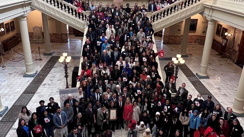 Immigrant advocates pose with Gov. Brian Kemp and Georgia first lady Marty Kemp at the Georgia Capitol on Tuesday, February 14 2023. (Photo courtesy of the Coalition of Refugee Service Agencies)