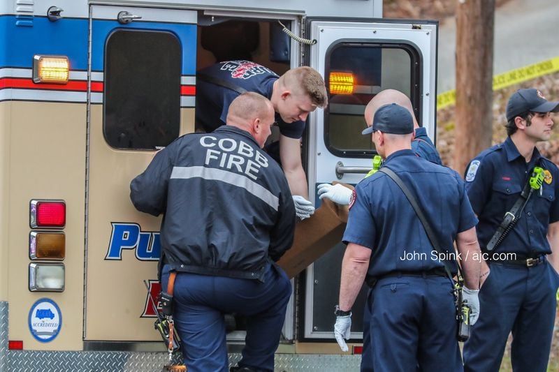 Medics with Cobb fire treat a shooting suspect in the back of an ambulance after the man was apprehended outside a Veterans Memorial Highway home Tuesday morning.