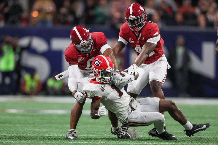 Georgia Bulldogs wide receiver Marcus Rosemy-Jacksaint (1) is stopped by Alabama Crimson Tide defensive backs Kristian Story (4) and Jaylen Key (6) after a first down during the first half of the SEC Championship football game at the Mercedes-Benz Stadium in Atlanta, on Saturday, December 2, 2023. (Jason Getz / Jason.Getz@ajc.com)